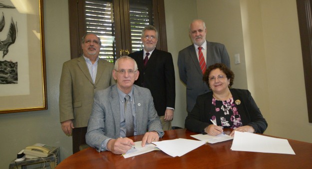 En primer plano, el Rector del RUM, John Fernández Van Cleve y la decana ejecutiva asociada de Enseñanza y Aprendizaje de la Escuela de Medicina Veterinaria de Ross, Carmen Fuentealba, en la firma oficial del acuerdo. Atrás, los doctores Antonio González Quevedo, decano de Asuntos Académicos; José R. Latorre, director del Departamento de Ciencia Animal y Raúl Macchiavelli, decano del Colegio de Ciiencias Agrícolas.