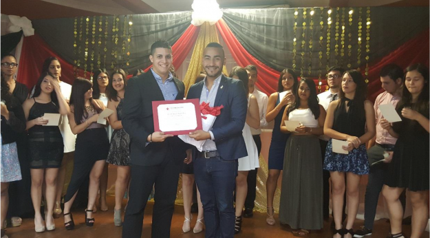 El Sr. Miguel Hernández, Coordinador de Servicios de Voluntarios entrega a Kenneth López, presidente de CRAUPRAg, el certificado que los reconoce como organización estudiantil afiliada a la Cruz Roja Americana El Sr. Miguel Hernández, Coordinador de Servicios de Voluntarios entrega a Kenneth López, presidente de CRAUPRAg, el certificado que los reconoce como organización estudiantil afiliada a la Cruz Roja Americana