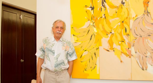 Nelson Sambolín junto a la obra en lienzo ¡Amarillo, amarillo, los plátanos!
