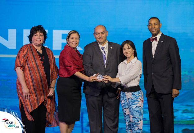 La doctora Moraima De Hoyos-Ruperto, segunda desde la izquierda; y la estudiante Jahannie Torres Rodríguez, cuarta, en el mismo orden; reciben el premio por el mejor artículo científico en la categoría de América del Norte y del Sur en el ICSB 2019 en Egipto. (Foto cortesía de ICSB) La doctora Moraima De Hoyos-Ruperto, segunda desde la izquierda; y la estudiante Jahannie Torres Rodríguez, cuarta, en el mismo orden; reciben el premio por el mejor artículo científico en la categoría de América del Norte y del Sur en el ICSB 2019 en Egipto. (Foto cortesía de ICSB)