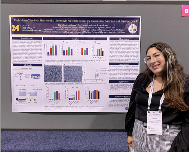 Screen Shot 2022-12-16 at 2.47.09 PM Diaris N. Báez Maldonado junto a su póster de investigación.