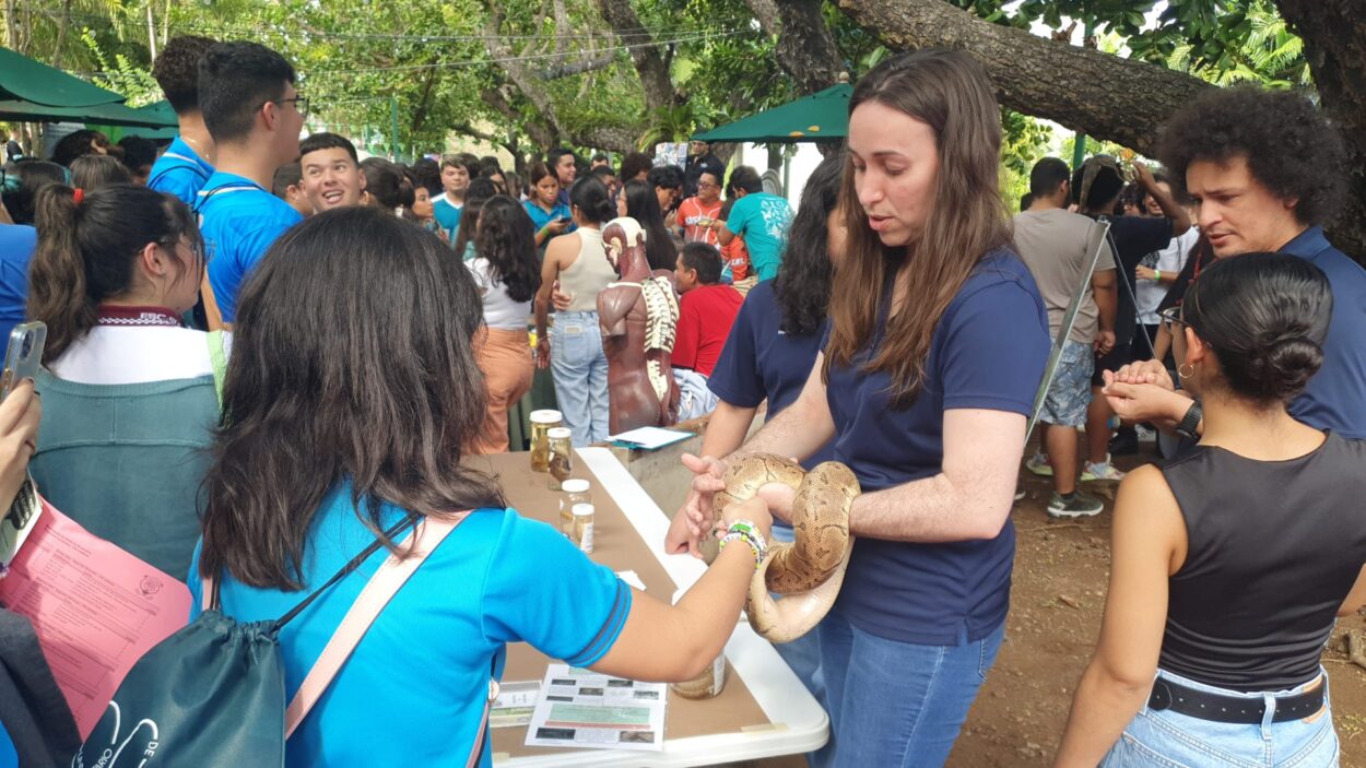 Estudiante del Departamento de Biología mostrando una Boa a un estudiante