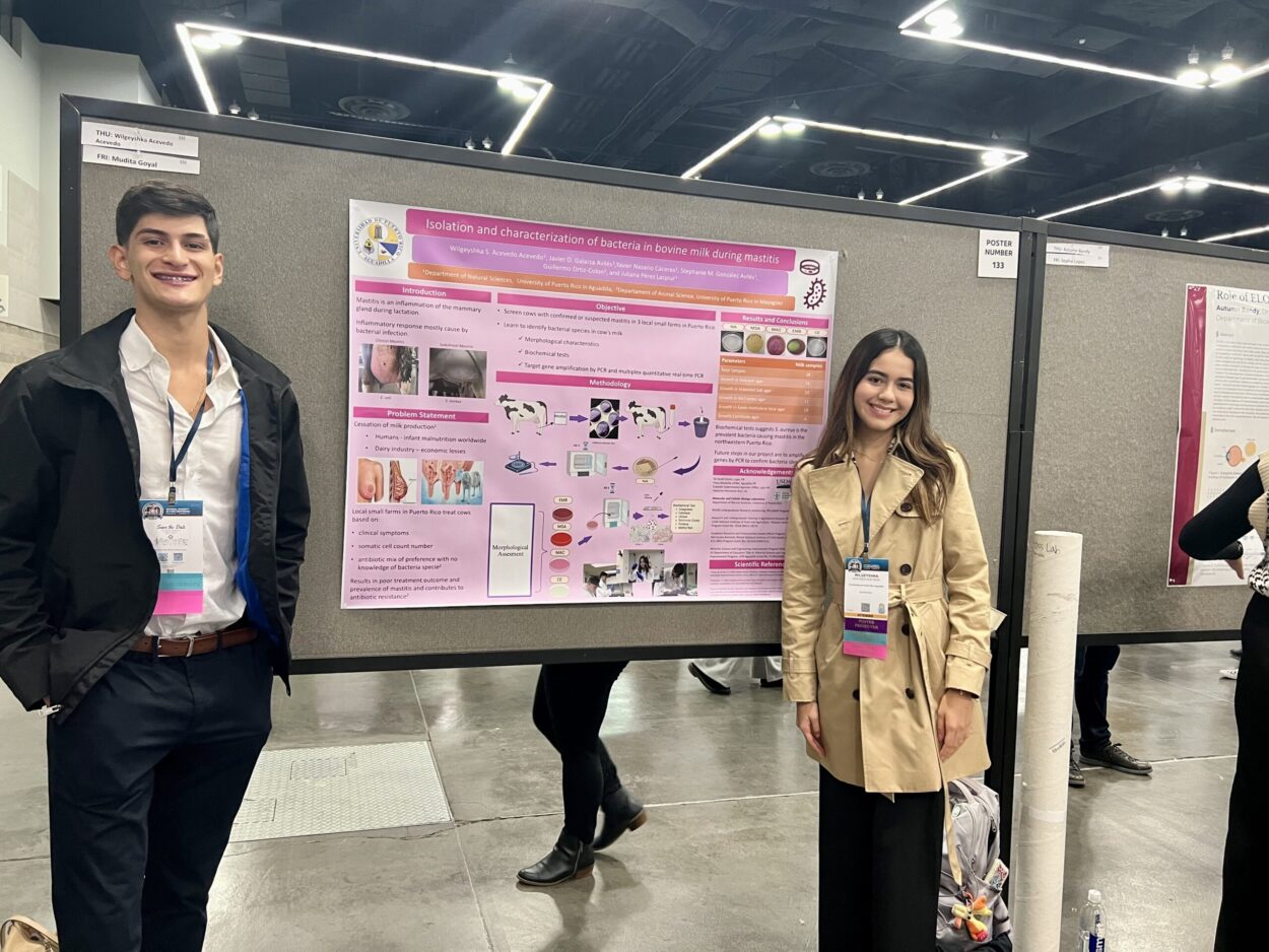 Los estudiantes Javier Galarza Avilés y Wilgeyshka Acevedo Acevedo junto a su póster de investigación.