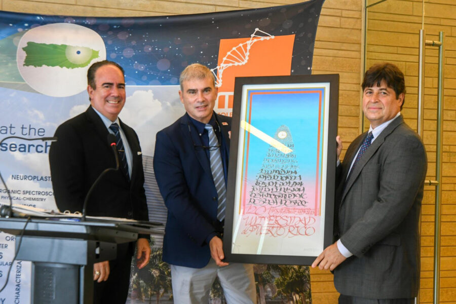 Dr. Luis A. Ferrao (Presidente de la UPR), Dr. Orestes R. Quesada, Vicepresidente Ejecutivo de la Vicepresidencia de Asuntos Académicos e Investigación, junto con el Dr. José A. Lasalde, sosteniendo el afiche conmemorativo de los 120 años de la UPR.