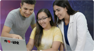 Tres estudiantes universitarios colaborando alrededor de una computadora portátil con un sticker de “Yo ❤️ la UPR”, representando el aprendizaje, la tecnología y el apoyo académico.
