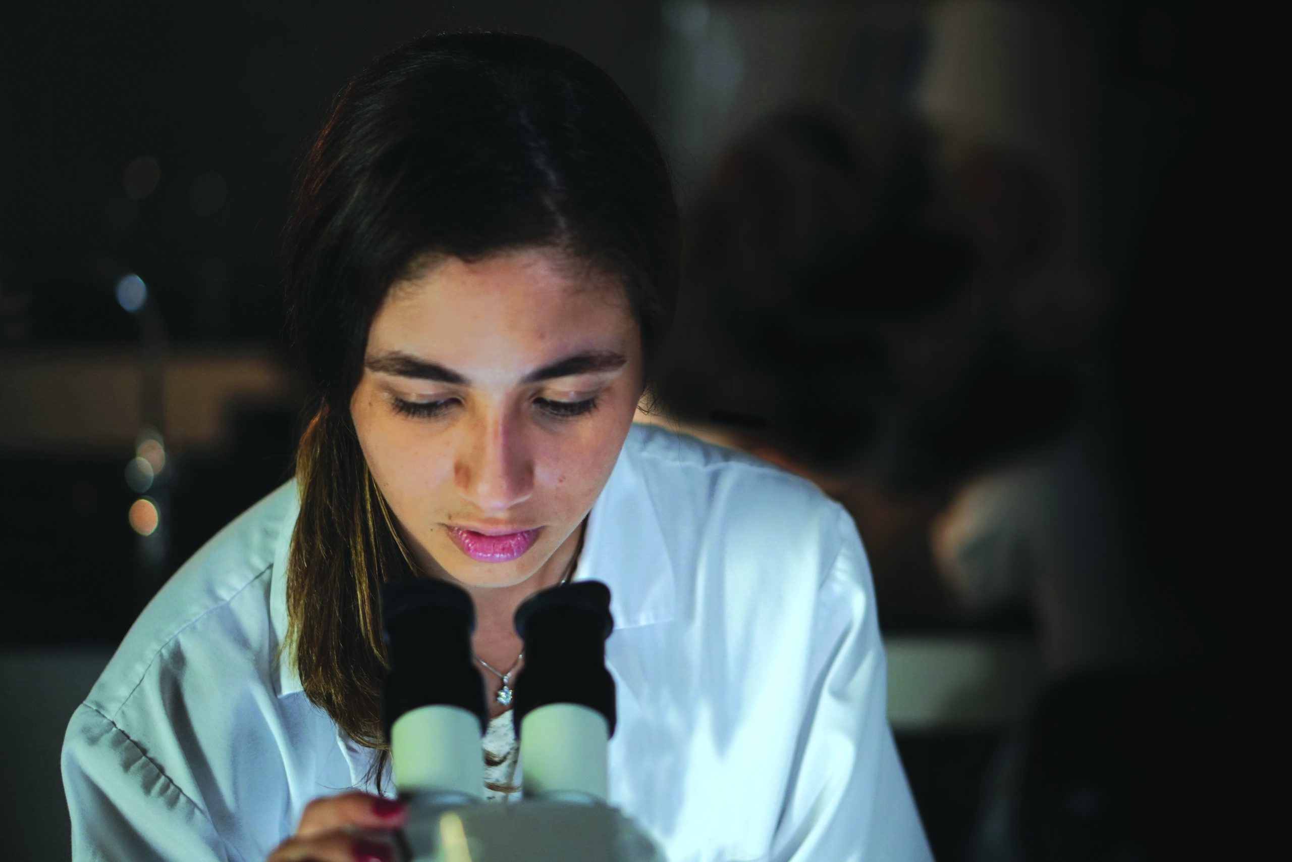 Una estudiante en un laboratorio utilizando un microscopio.