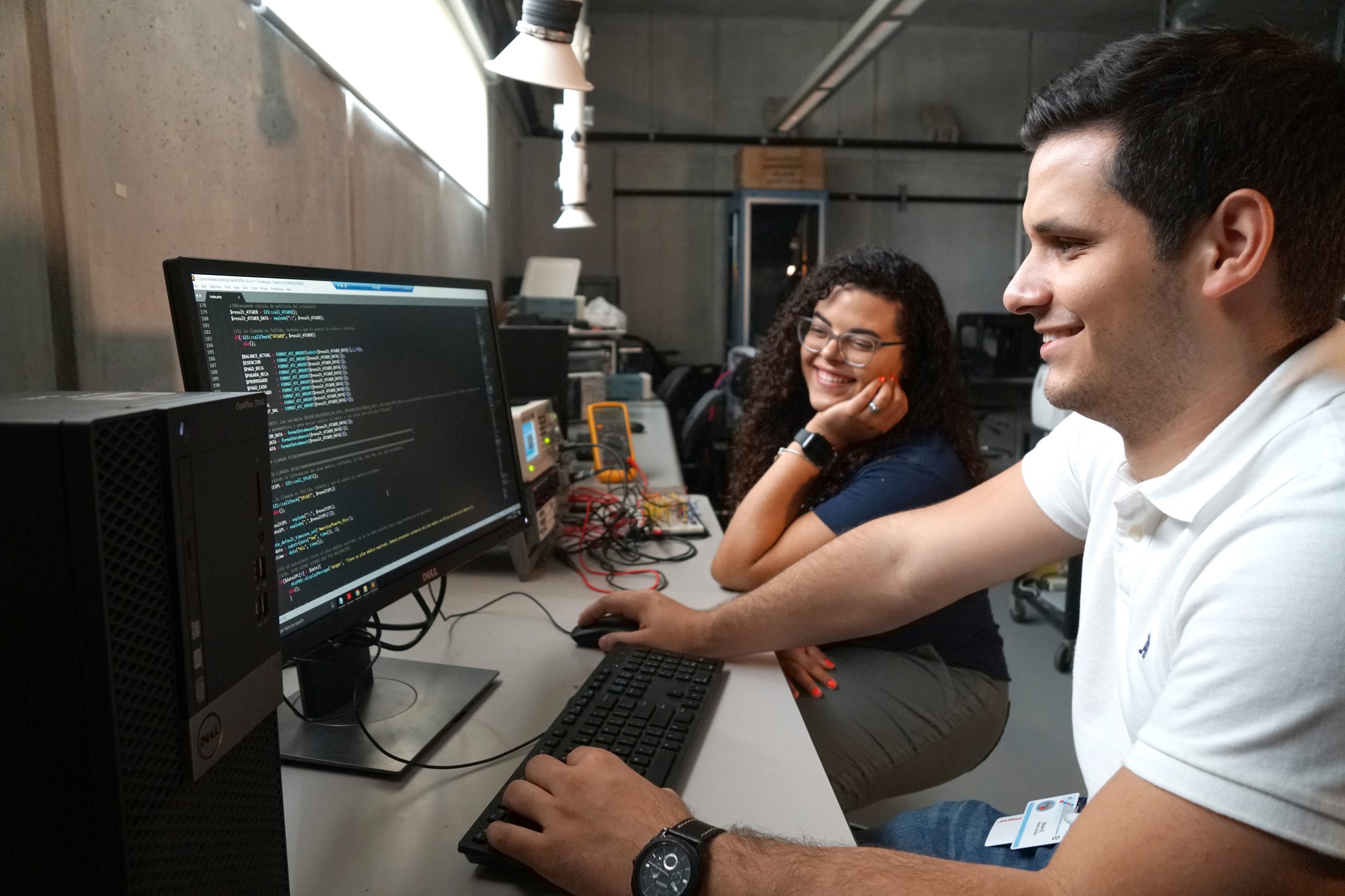 Dos estudiantes en un salón, utilizando una computadora