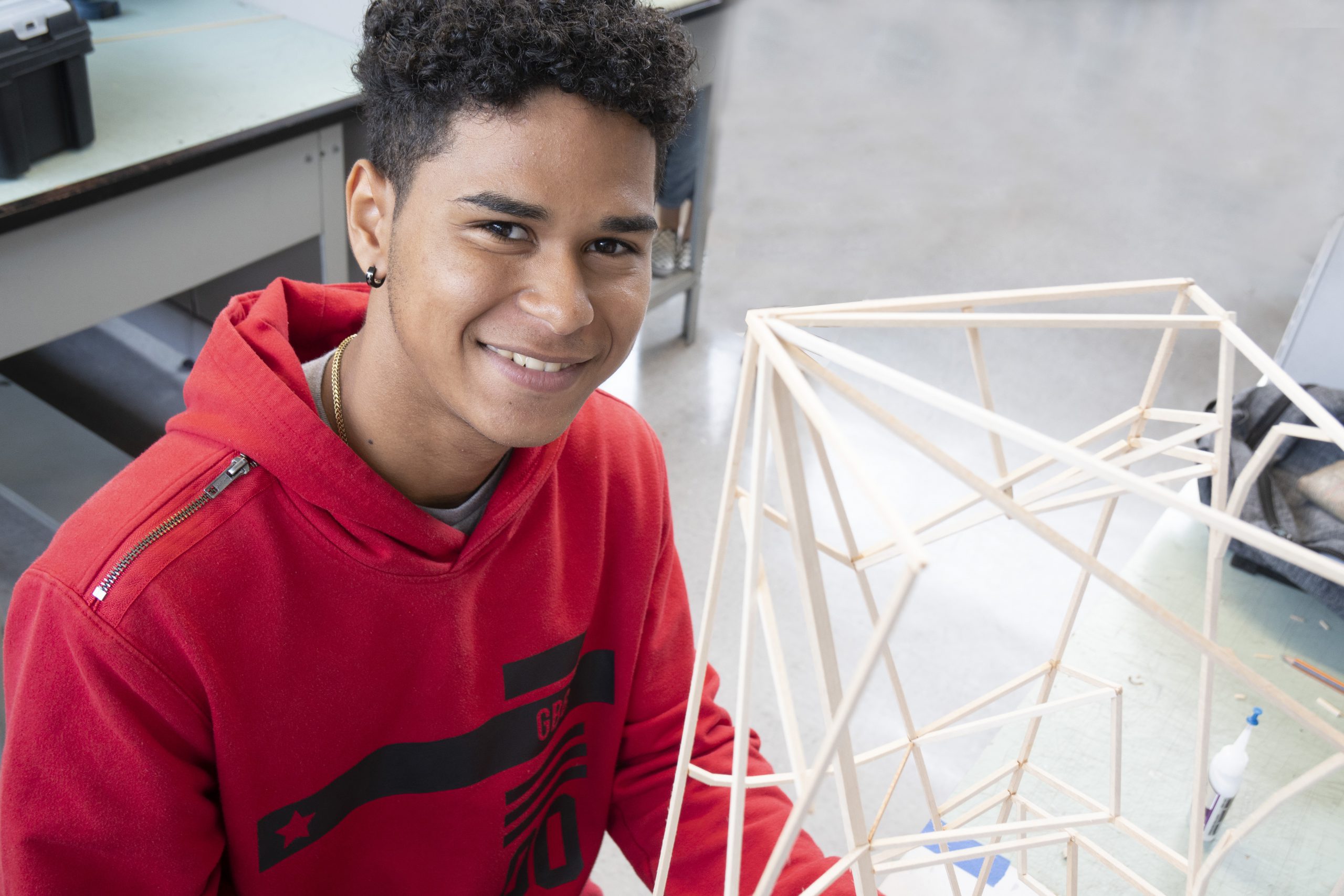 Foto de estudiante sosteniendo un modelo de arquitectura.