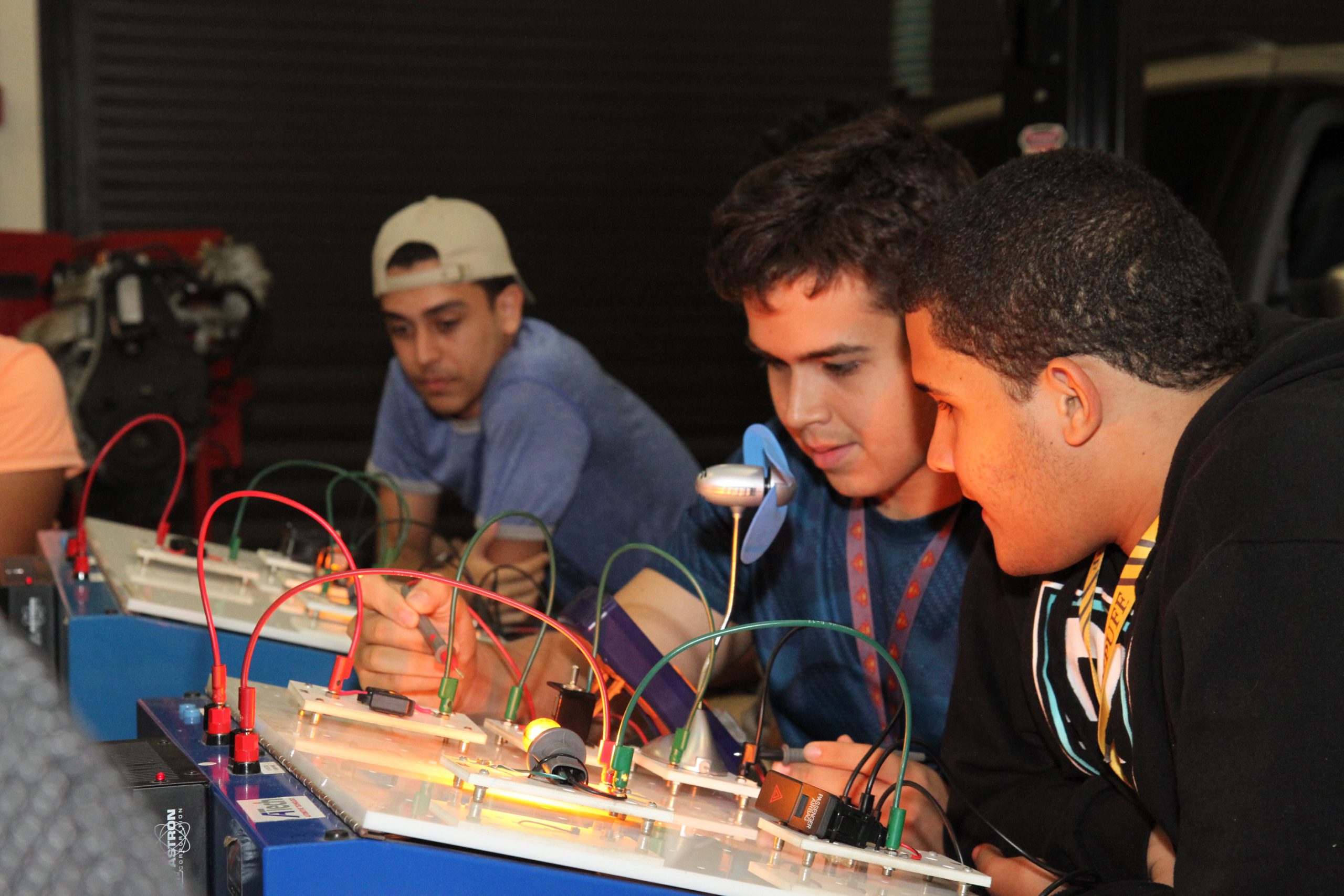 Varios estudiantes en un laboratorio de electrónica, utilizando tableros de circuitos. 