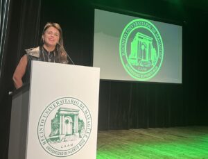 Glorimar Marrero Sánchez, detraz de un Podio con el sello de la Universidad de Puerto Rico Recinto de Mayagüez.