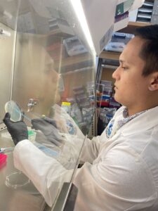 Jeremy J. Colón realizando investigación detrás de la campana de extracción.