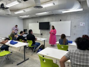 Otro ángulode la instructora frente a sus estudiantes en un salon de clases.