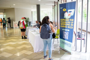 Estudiante observando afiche de la feria de empleo.