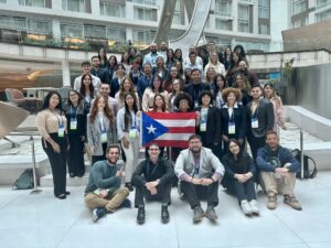 Un grupo de estudiantes universitarios y emergentes investigadores boricuas se reunió para tomarse una foto con la bandera de Puerto Rico.