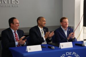 Luis A. Ferrao Delgado, Presidente de la UPR, José I. Meza Pereira, Rector de la UPR Carolina, y Brad Dean, Oficial ejecutivo de Discover Puerto Rico. Aplaudiendo, después de firmar alianza.