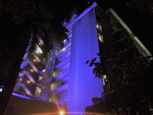 Edificio del Recinto de Ciencias Médicas iluminado en color púrpura.