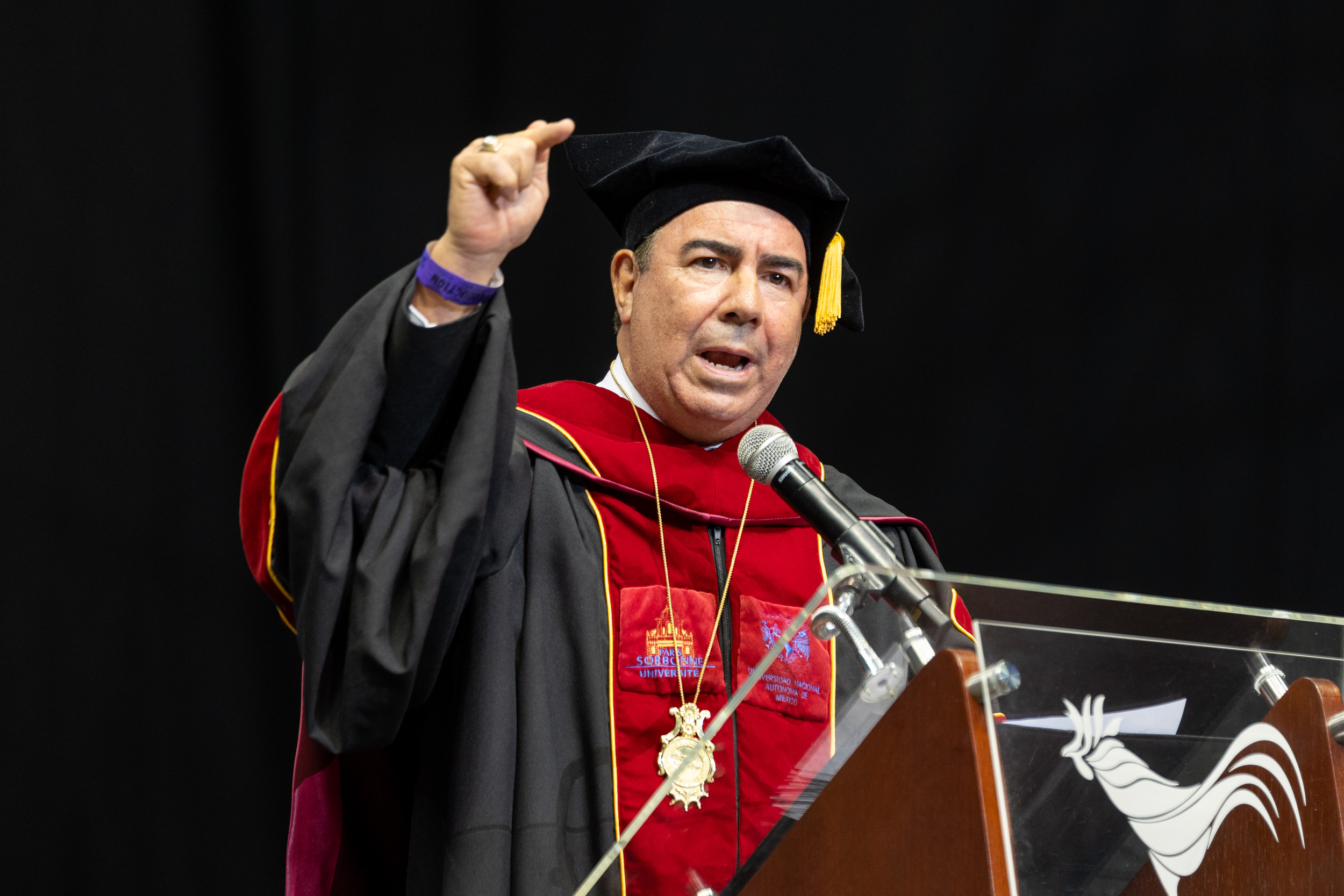 Grad-15 Dr, Luis Ferrao, Presidente de la UPR, detrás de un podio dirigiéndose a los graduados.