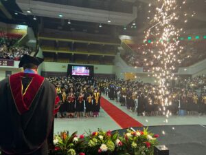 Otro ángulo de los graduandos de pie en la colación de grados.