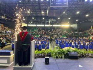 Vista de los graduandos de pie en la colación de grados.