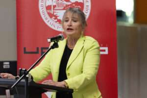 Dra. Angélica Varela Llavona, Rectora de la Universidad de Puerto Rico Recinto de Río Piedras, en el podio dirigiéndose al público