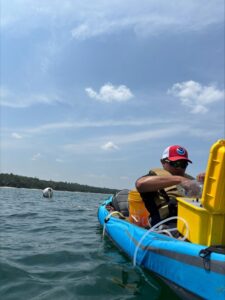Luis Miguel en un bote estacionado, operando unos instrumentos en una caja amarilla.