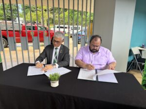 Agustín Rullán Toro, rector del RUM y el licenciado Eliezer Ramos Parés, secretario de Educación firmando documentos