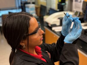 Alondra Rodriguez Rolon examinando una muestra de laboratorio.