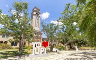 El Recinto de Río Piedras de la Universidad de Puerto Rico (RRP-UPR) renovó el acuerdo colaborativo para ostentar nuevamente la Cátedra UNESCO de Educación para la Paz, además de continuar con la Cátedra UNESCO Creación de Conocimiento, Innovación y Colaboración en la Educación Superior. “La renovación de la Cátedra UNESCO de Educación para la Paz refuerza el compromiso histórico del Recinto de Río Piedras de la UPR con la formación de ciudadanos y ciudadanas conscientes, solidarios y comprometidos con la transformación social. Este reconocimiento internacional valida la excelencia académica de nuestra comunidad universitaria y su liderazgo en la promoción de una cultura de paz fundamentada en los derechos humanos, el diálogo y la justicia social”, indicó la rectora de la UPR-Río Piedras, doctora Angélica Varela Llavona. Asimismo, “la continuidad de la Cátedra UNESCO de Creación de Conocimiento, Innovación y Colaboración en la Educación Superior fortalece nuestra misión de impulsar la investigación, la creatividad y las alianzas estratégicas que posicionan al recinto como referente regional e internacional. Ambas cátedras representan una plataforma para ampliar nuestro impacto global, fomentar redes de colaboración y contribuir de manera significativa al desarrollo sostenible de Puerto Rico y del mundo”, dijo. Por su parte, la presidenta de la UPR, doctora Zayira Jordán Conde, expresó que “la renovación y continuidad de estas dos Cátedras UNESCO en el Recinto de Río Piedras reafirma el posicionamiento internacional de la Universidad de Puerto Rico como un centro de excelencia académica, investigación colaborativa y compromiso social. Desde la Presidencia, impulsamos una universidad conectada con el mundo, que construye conocimiento, promueve la paz y lidera la transformación educativa que Puerto Rico y la región necesitan”. La Cátedra de Educación para la Paz -coordinada por la doctora Anita Yudkin, profesora de la Facultad de Educación- es un proyecto transdisciplinario comprometido con la educación, la investigación y la colaboración para construir una cultura de paz, derechos humanos y sustentabilidad. Este convenio de cooperación se renovó hasta diciembre de 2029. En vísperas de su 30⁰ aniversario, la cátedra continuará construyendo su misión a través de conferencias, foros, seminarios, talleres y conversatorios; iniciativas de investigación y creación en temas emergentes en la educación para la paz; investigaciones y publicaciones en revistas y libros especializados; la producción y divulgación de materiales didácticos; la difusión del proyecto “Buenas Prácticas de Cultura de Paz”, y actividades como el evento “Tallereando por la Paz” y su conferencia magistral anual. Asimismo, continuará colaborando con otras Cátedras UNESCO de la región, la Red Latinoamericana y Caribeña de Educación en Derechos Humanos (RedLaCDEH), el Global Campaign for Peace Education (GCPE) y el International Institute on Peace Education (IIPE). Mientras, la Cátedra UNESCO Creación de Conocimiento, Innovación y Colaboración en la Educación Superior -cuya titular es la doctora Eunice Pérez-Medina, decana asociada de Asuntos Académicos de la Facultad de Estudios Generales- busca promover la transformación de la educación superior y fortalecer el conocimiento mediante la investigación y la colaboración local e internacional. Esta cátedra se establece como parte del UNITWIN/UNESCO Chairs Programme, y forma parte de una red internacional de iniciativas en más de 120 países. Dentro del campus, esta cátedra se ha convertido en un puente más hacia la internacionalización, posicionando al recinto como núcleo en la red académica global que UNESCO fomenta para fortalecer la educación superior. A través de esta plataforma la universidad afianza su papel en iniciativas de investigación colaborativa, proyectos de capacitación docente y estudios sobre políticas educativas que conectan a Puerto Rico con académicos e instituciones de todo el mundo. La presencia de esta cátedra en el recinto riopedrense ha tenido resultados concretos. En 2025, la universidad fue sede del Encuentro de Cátedras UNESCO de América Latina y el Caribe, un evento que reunió a investigadores y docentes de múltiples países. Se espera que iniciativas como esta se intensifiquen y se traduzcan en más oportunidades académicas y profesionales para la comunidad universitaria.