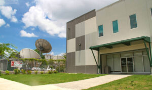 Fachada de la emisora de radio, y al lado antenas parabólicas de transmisión.