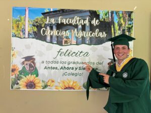 Andrew Hermann Holland frente a un cartelde la facultad de Ciencias Agrícolas.