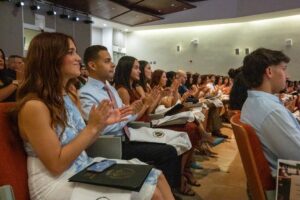 Estudiantes sentados en anfiteatro aplaudiendo