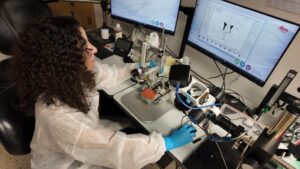 Investigadora leyendo medidas en unos monitores en el laboratorio.