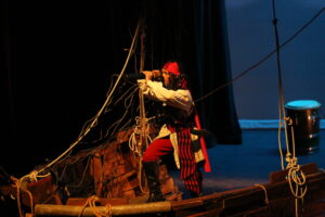 Escena de obra El mapa de la Libertad. María Isabel en cubierta del barco observando con un telescopio.
