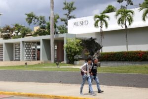 Dos estudiantes caminando frente a la Fachada del Museo de la UPR Río Piedras